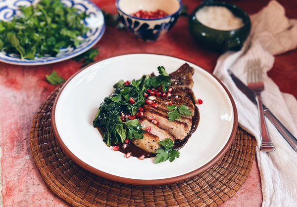 SEARED PORK CHOPS WITH MOLE ROJO, WILTED GREENS & POMEGRANATES